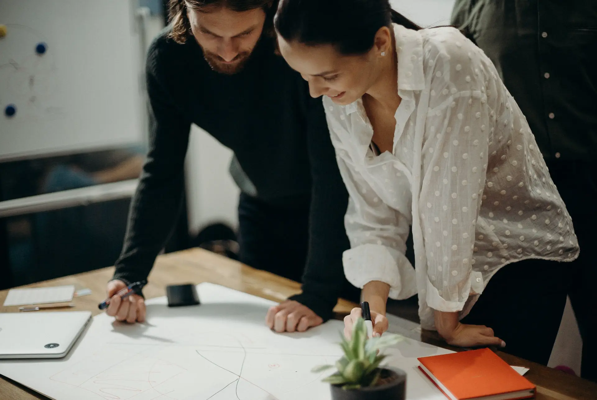 People collaborating drawing a sketch smiling